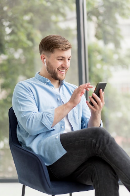 Jonge man met airpods via telefoon