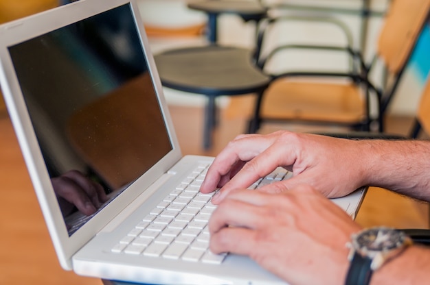 Jonge man met behulp van laptop op de klas