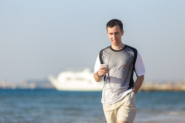 Jonge man met behulp van mobiele telefoon op zee