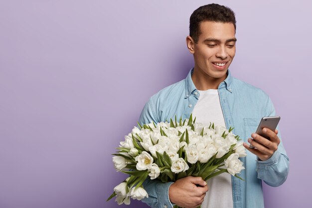Jonge man met boeket van witte bloemen