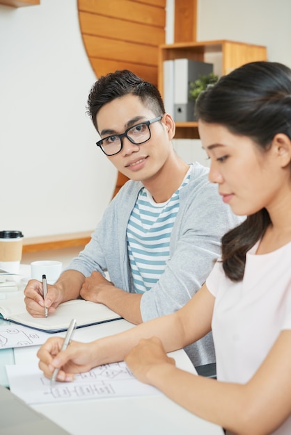 Jonge man met coworking vrouw in kantoor