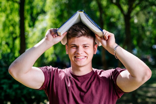 Jonge man met een boek op het hoofd