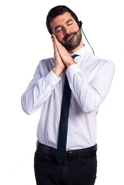 Jonge man met een headset die slaapgebaar doet