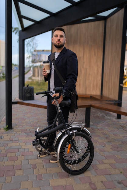 Gratis foto jonge man met een vouwfiets in de stad