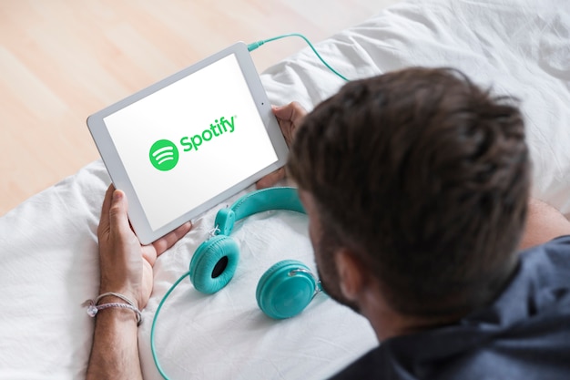 Gratis foto jonge man met modern apparaat met spotify app