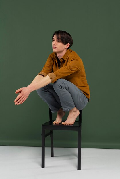 Jonge man met shirt poseren op stoel