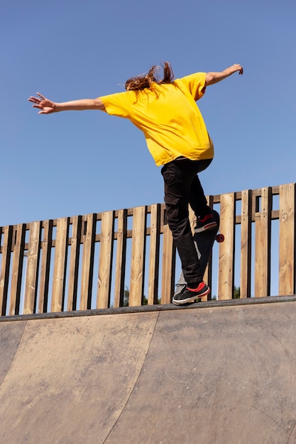 Gratis foto jonge man met skateboard die volledig schot springt