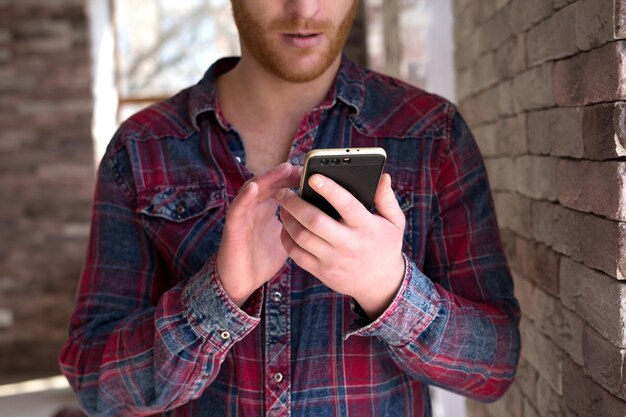 Jonge man met telefoon in zijn hand die onderzoek doet