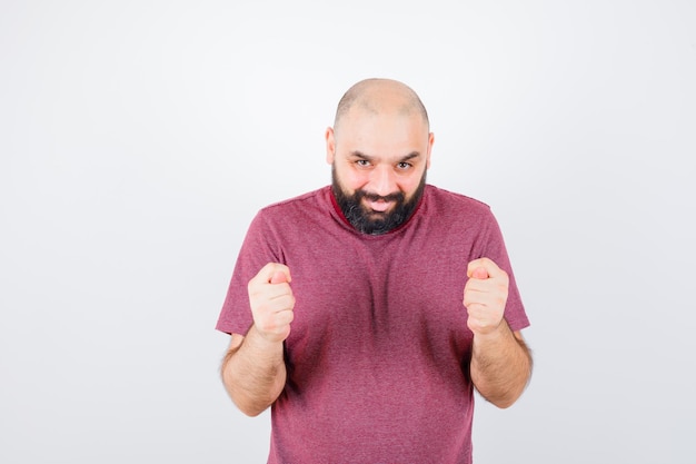 Jonge man met vijgengebaar in roze t-shirt, vooraanzicht.