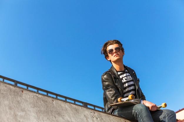 Jonge man met zijn skateboarden op de skatepark