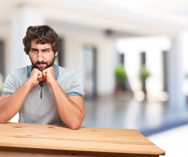 Jonge man op een tafel. bezorgde uitdrukking