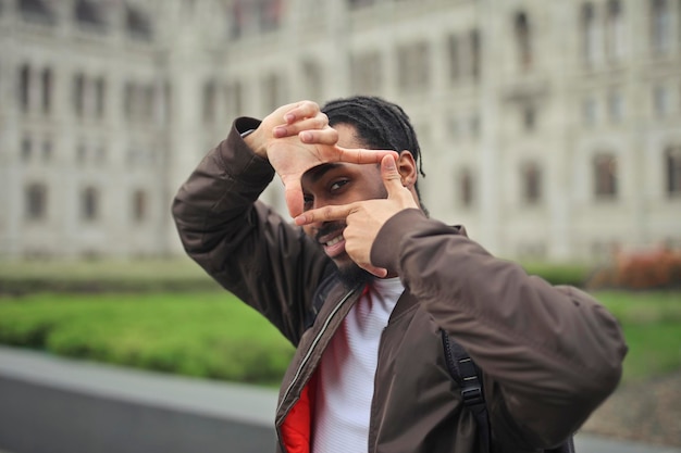 jonge man op straat maakt met zijn handen een kader rond zijn oog