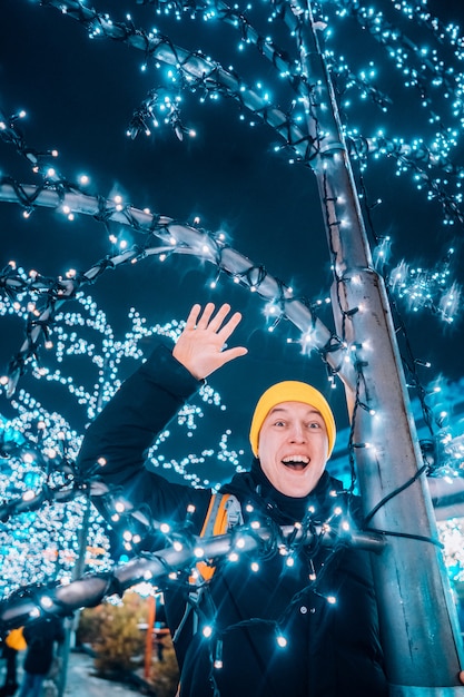 Jonge man op straat met verlichte bomen