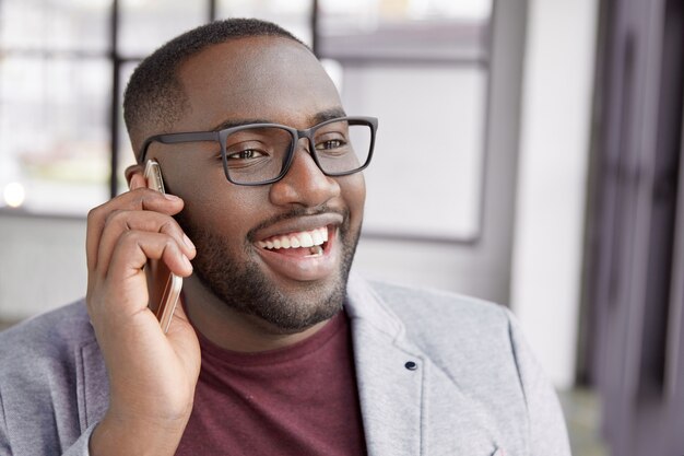 Jonge man praten aan de telefoon