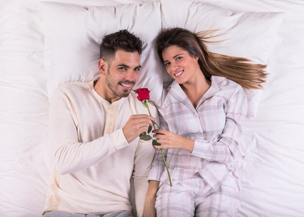 Jonge man ruiken steeg in bed met vrouw