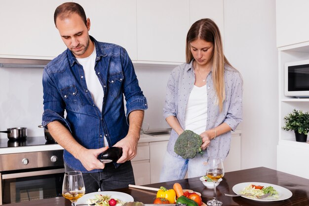 Jonge man snijden van de groenten in de keuken