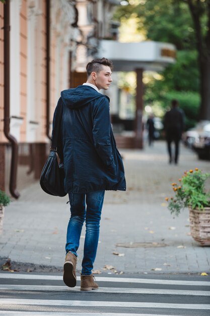 Jonge man steekt de straat over