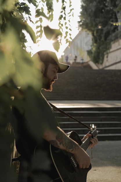 jonge man straatmuzikant speelt gitaar en zingt. Straatmuziek concept.