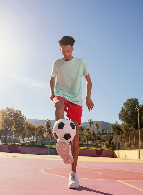 Gratis foto jonge man voetballen