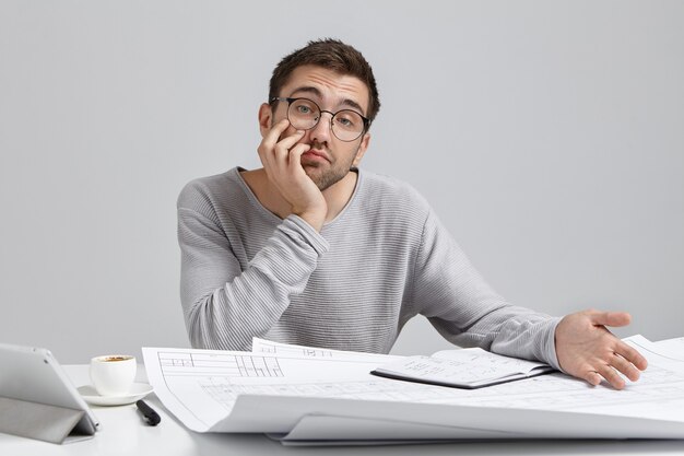 Jonge man zit aan bureau en doet papierwerk