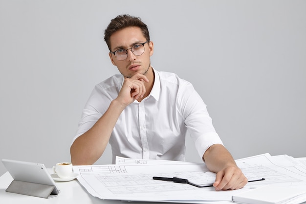 Jonge man zit aan bureau en doet papierwerk