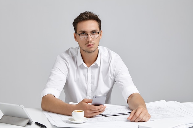 Jonge man zit aan bureau en doet papierwerk