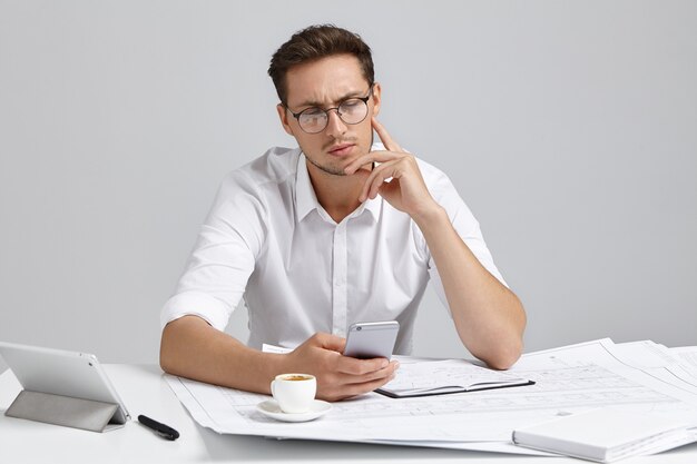 Jonge man zit aan bureau en doet papierwerk