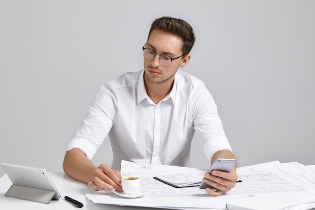 Jonge man zit aan bureau en doet papierwerk