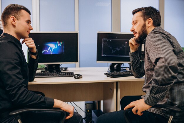 Jonge mannelijke webontwerpers die aan een computer werken