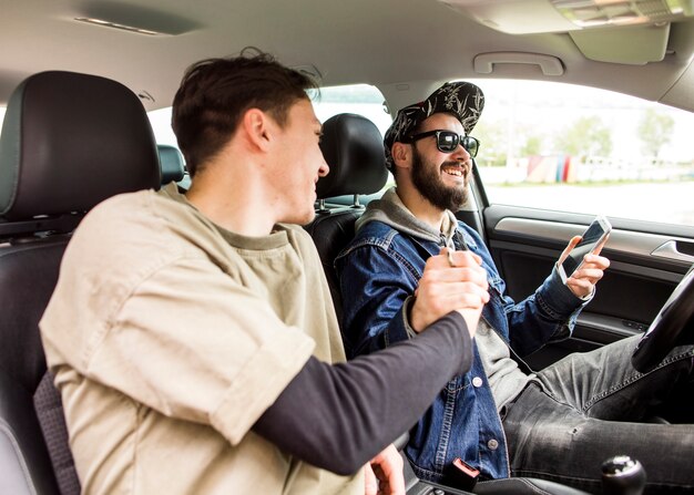 Jonge mannen begroeten elkaar in de auto