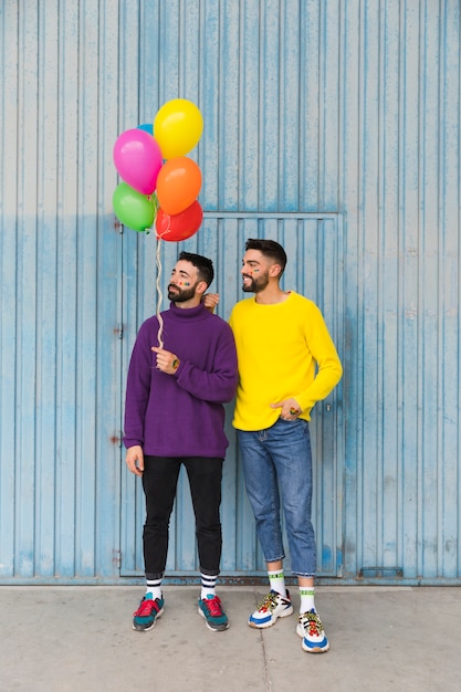 Jonge mannen die zich met ballons bevinden