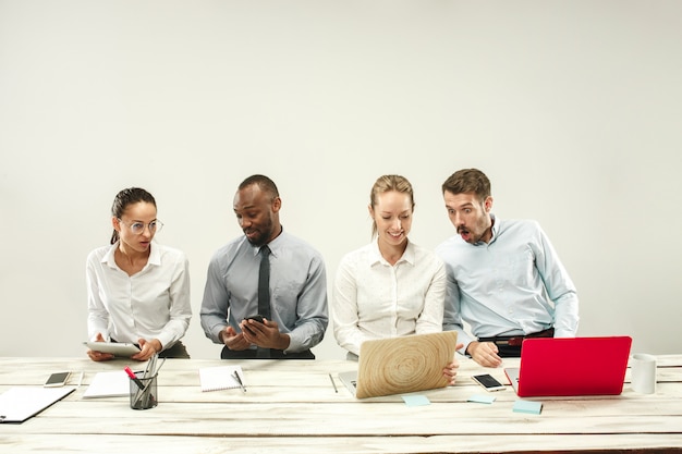 Gratis foto jonge mannen en vrouwen die op kantoor zitten en aan laptops werken. emoties concept