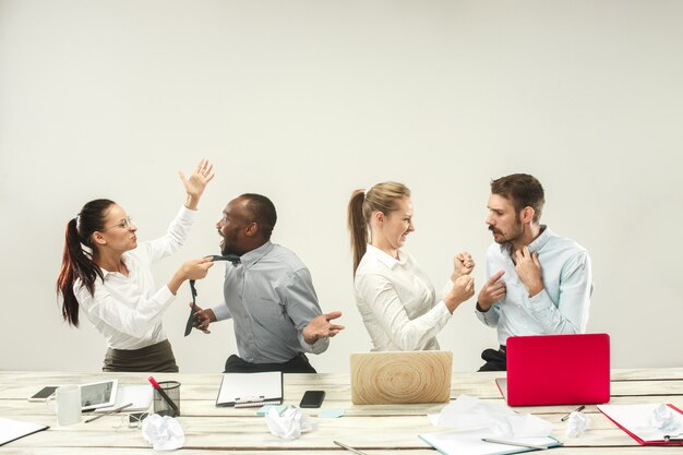 Jonge mannen en vrouwen die op kantoor zitten en aan laptops werken. Emoties concept