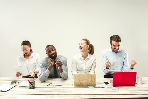 Jonge mannen en vrouwen die op kantoor zitten en aan laptops werken. Emoties concept