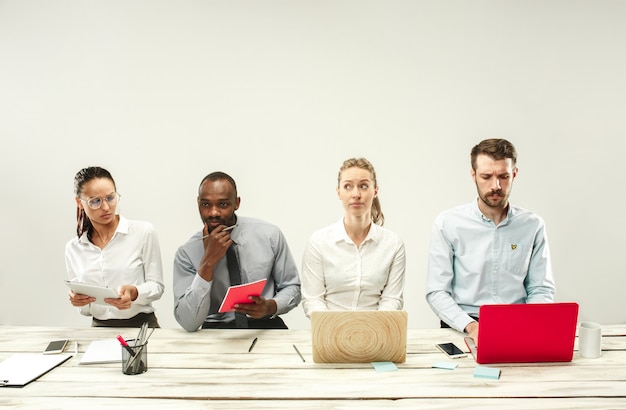 Jonge mannen en vrouwen die op kantoor zitten en op laptops werken. Emoties concept