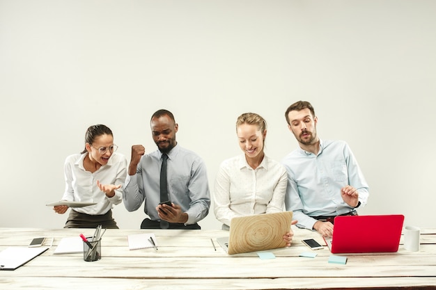 Gratis foto jonge mannen en vrouwen die op kantoor zitten en op laptops werken.