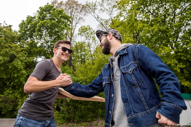 Jonge mannen verwelkomen elkaar in de natuur