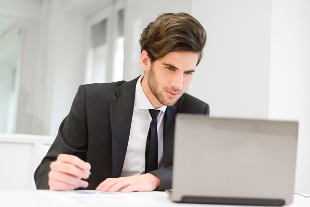 Jonge medewerker werkt op zijn verslag