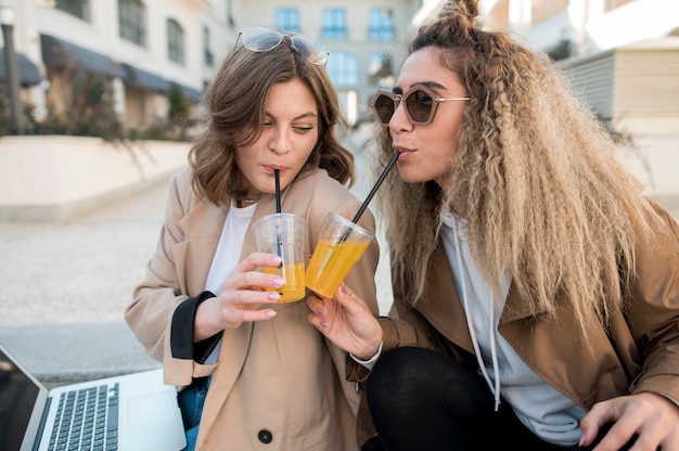 Gratis foto jonge meisjes die jus d'orange drinken