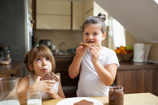 Jonge meisjes die ochtendontbijt hebben thuis