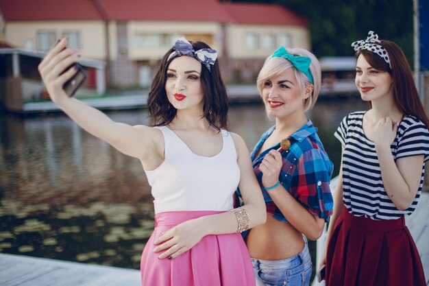 Jonge meisjes poseren voor een auto-foto met de zee achtergrond