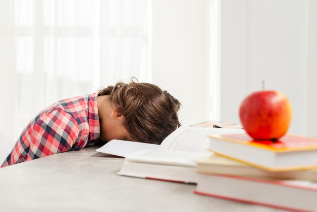 Jonge meisjesslaap in plaats van het bestuderen