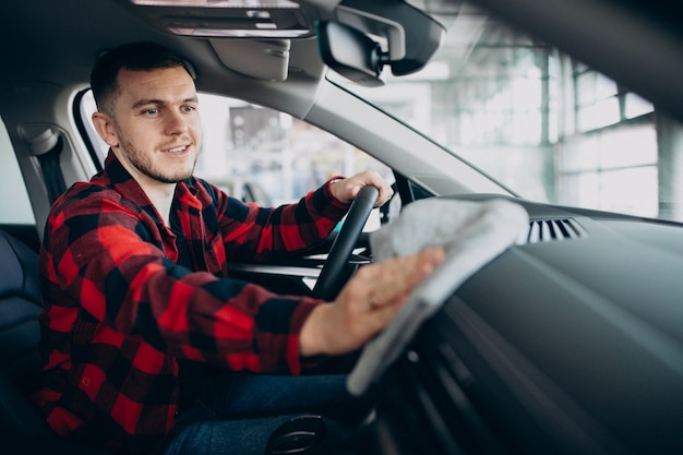 Gratis foto jonge mens die zijn auto met vod oppoetst