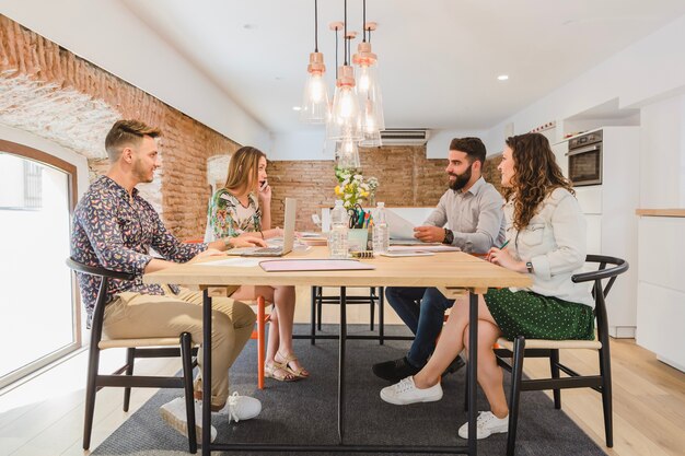 Jonge mensen die aan tafel communiceren