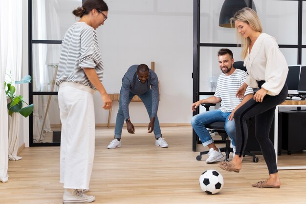 Jonge mensen spelen met de bal op kantoor