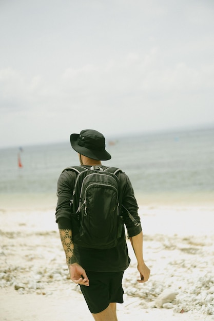 Gratis foto jonge mensenreiziger op het strand.