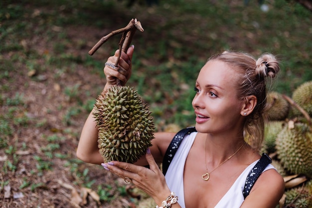 Jonge mode vrouw op een tropisch veld met durian fruit