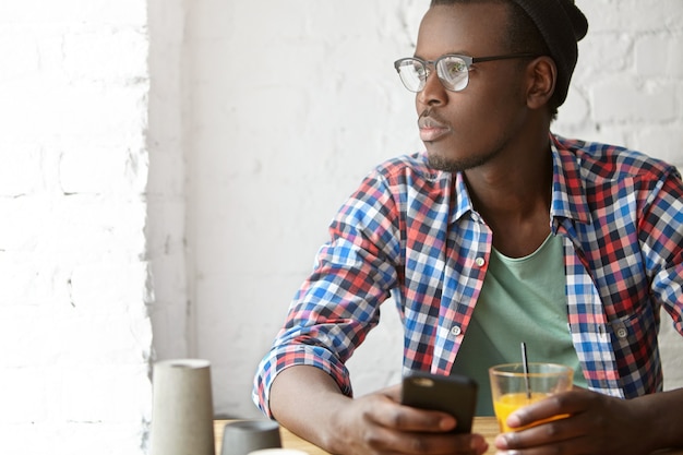 jonge modieuze man zit in een café