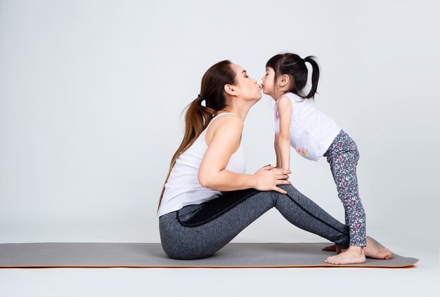 Jonge moeder die mooie dochter met gymnastiek opleidt