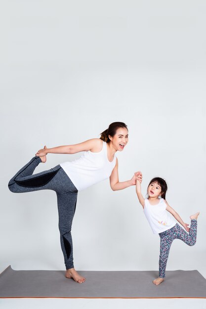 Jonge moeder die mooie dochter met gymnastiek opleidt